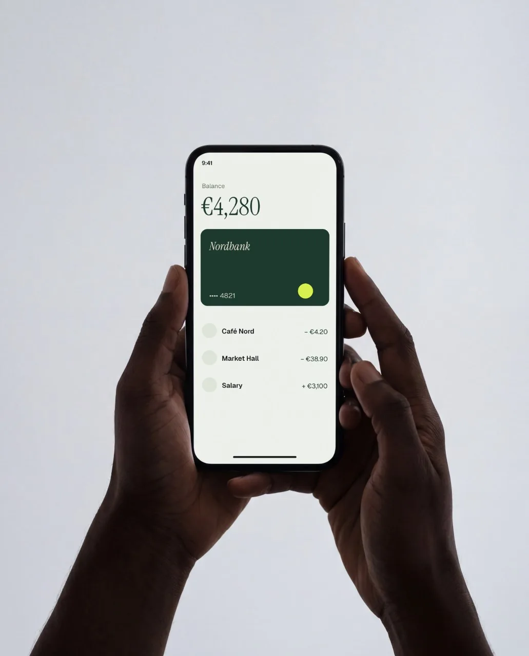 Mockup: Celular nas duas mãos, estúdio cinza