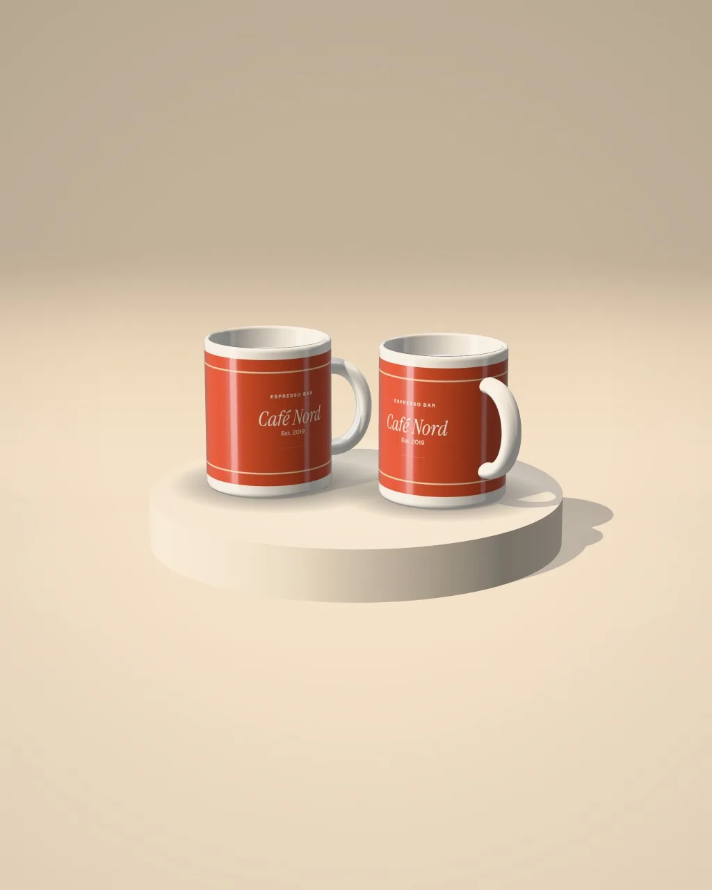 Mockup: Dupla de canecas sobre um pódio cor de areia