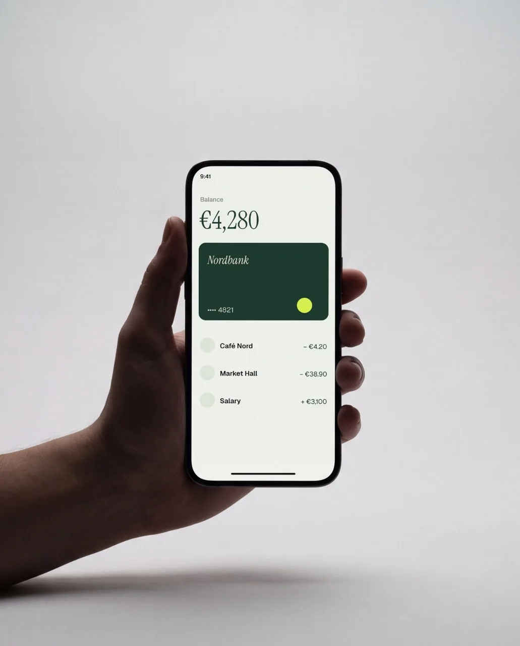 Mockup: Móvil en la mano, estudio gris