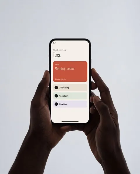 Phone in two hands, grey studio mockup